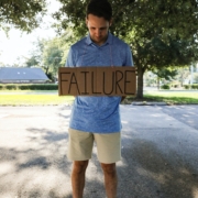 Man holding sign that says "failure"