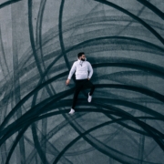 man lying on road with burnout marks