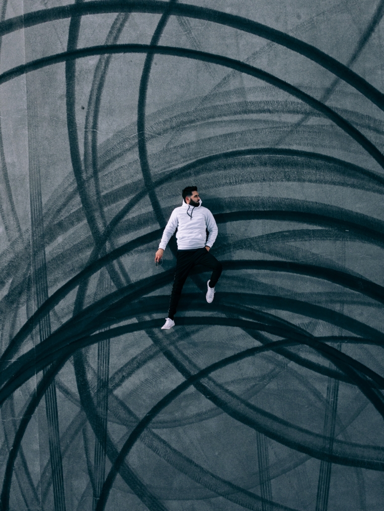 man lying on road with burnout marks