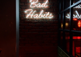 neon sign reads "bad habits"