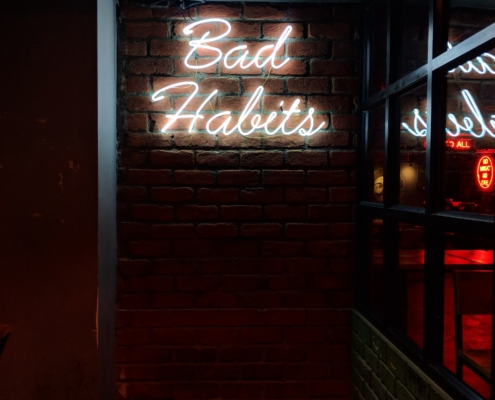 neon sign reads "bad habits"